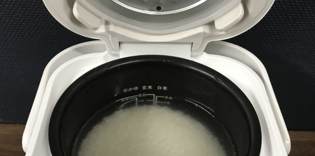 炊飯器の内釜に水分多めのおかゆ状の米が入っている、蓋を開けた状態のアップ写真