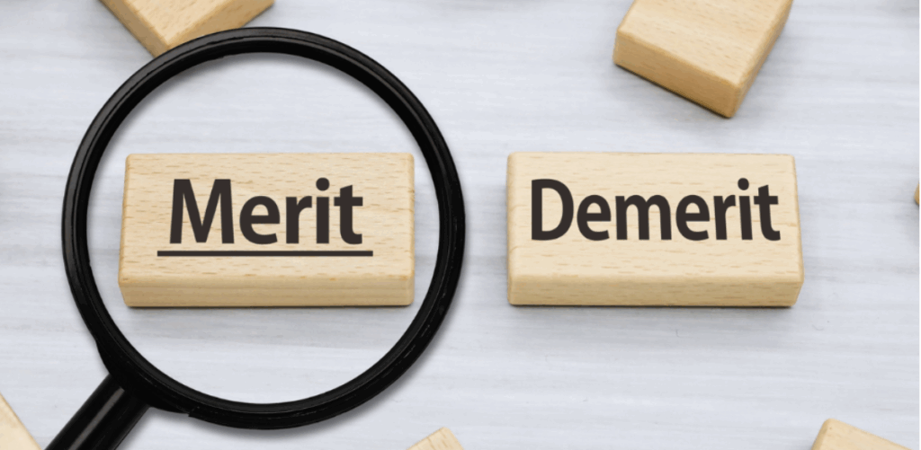 「Merit」と書かれた木製ブロックを虫眼鏡で強調し、隣に「Demerit」のブロックが置かれている