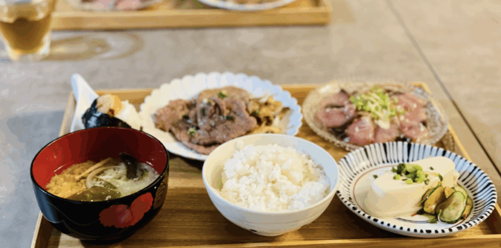 味噌汁・白ご飯・漬物・牛肉炒めなどが乗った木製トレーの和定