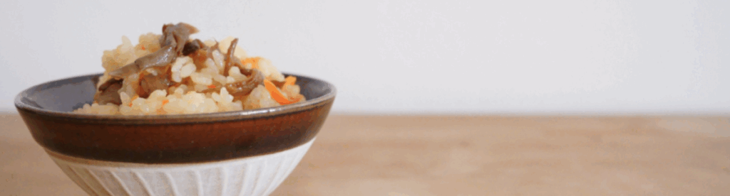 舞茸と人参が入った和風炊き込みご飯を盛り付けた茶碗